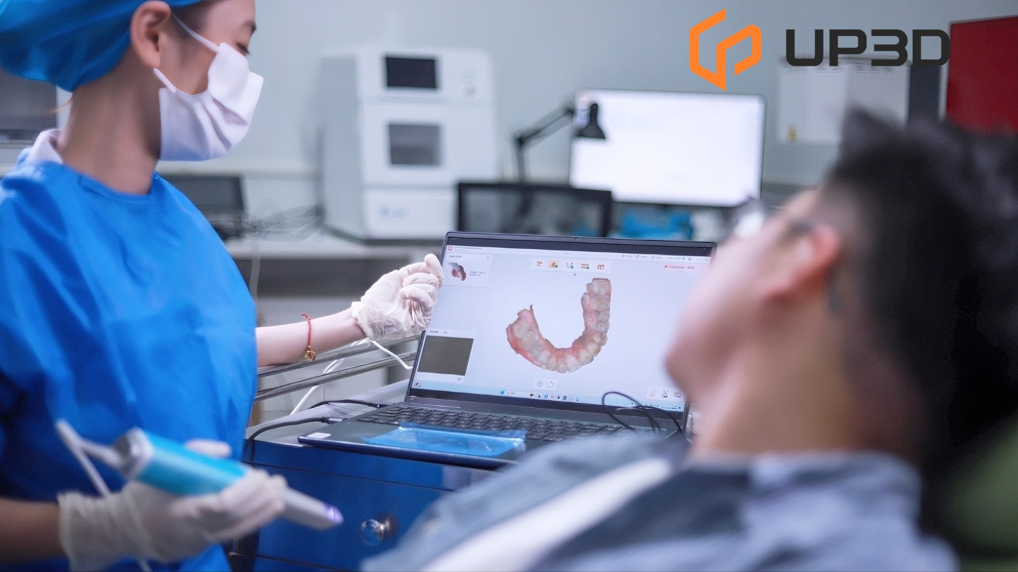 Dentist using UP3D intraoral scanner to capture digital impressions on a laptop screen