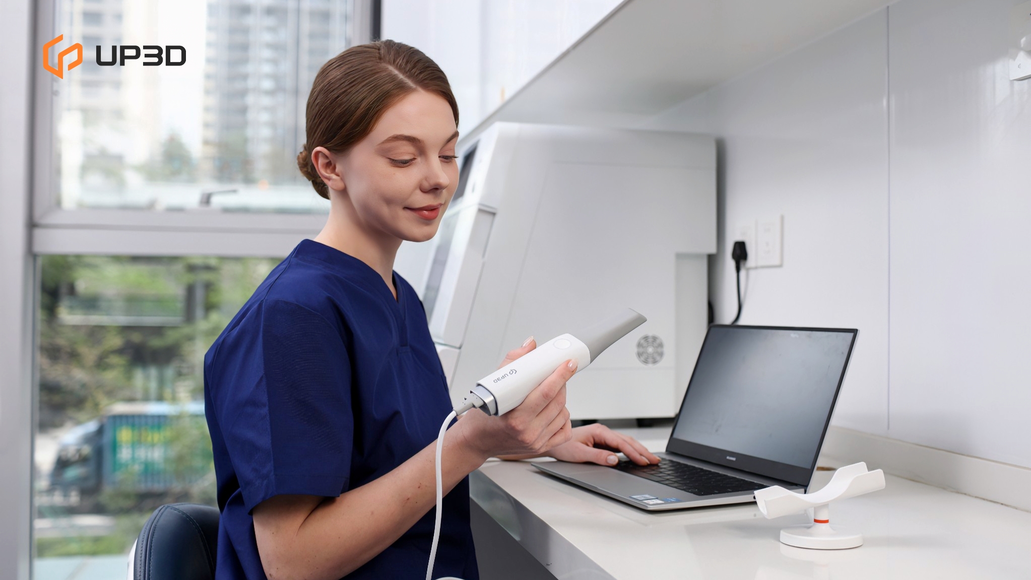 Dentist using UP3D UP610 intraoral scanner connected to laptop, preparing for a digital dental workflow in a modern clinic.