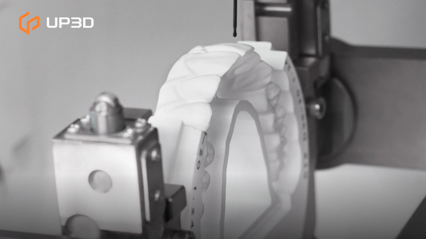 Close-up of a UP3D 5-axis dental milling machine precisely milling a dental restoration model, showing high accuracy and smooth surface details.